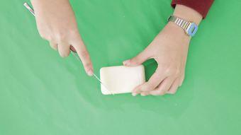 Photograph of hands carving soap